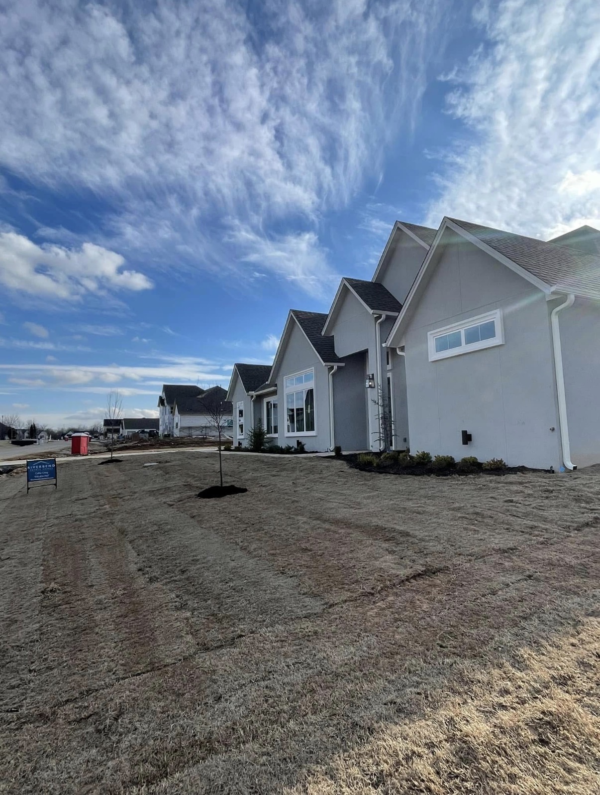 New-construction homes with freshly laid sod and planted trees